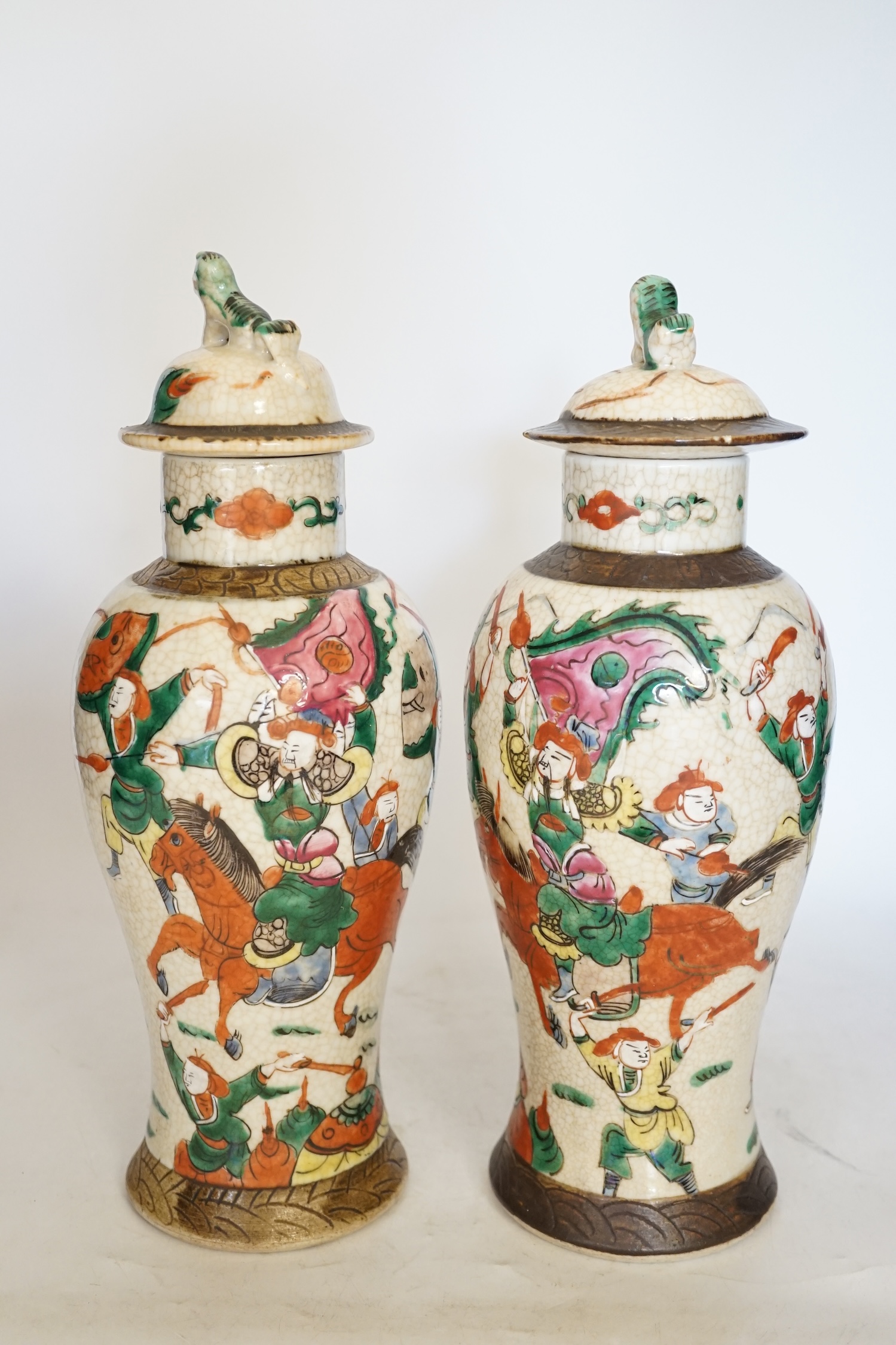 A pair of 19th century Chinese famille rose crackle glaze vases and covers, 31cm. Condition - fair to good